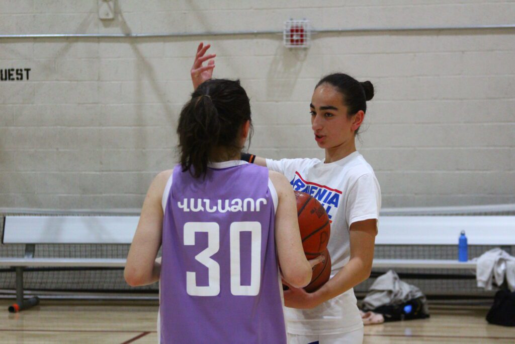 An Armenia basketball player coaching another Armenian basketball player during an open gym in Arizona. 