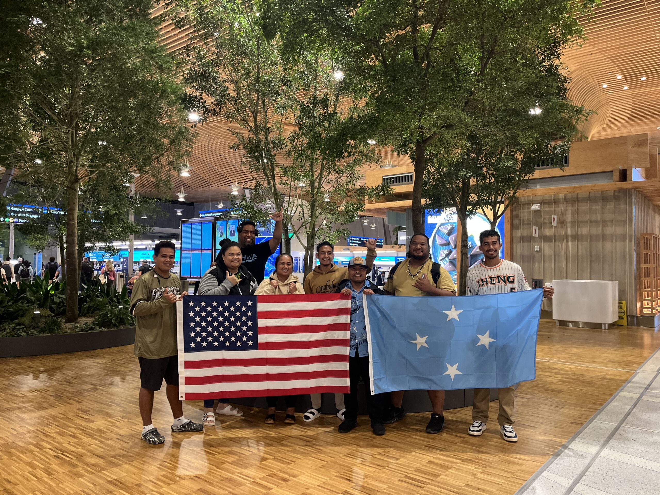 Micronesia participants group photo with the American and Micronesian flag in the Portland airport.